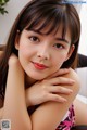 A young woman with long brown hair and bangs posing for a picture.