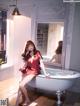 A woman sitting in a bathtub in front of a mirror.