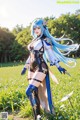 A woman with long blue hair standing in a field.