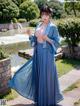 A woman in a blue hanfu is posing for a picture.