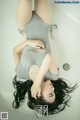 A woman laying in a bathtub with her legs up.