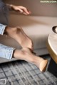 A woman sitting on a couch with her feet up on a table.