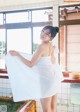 A woman in a white towel standing in a bathroom.