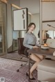 A woman sitting at a desk with a laptop computer.